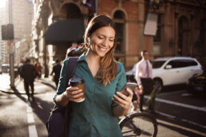 A woman consults a large language model AI on her smartphone while taking a walk through a city.